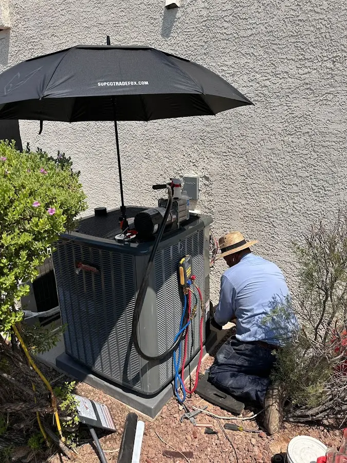 HVAC technician performing outdoor AC maintenance in Riverdale